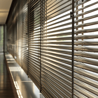 Close view of aluminium blind slats filtering sunlight
