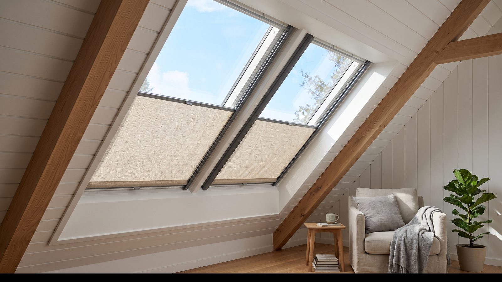 Fabric skylight blind running in side channels across an angled roof window in a sloping ceiling